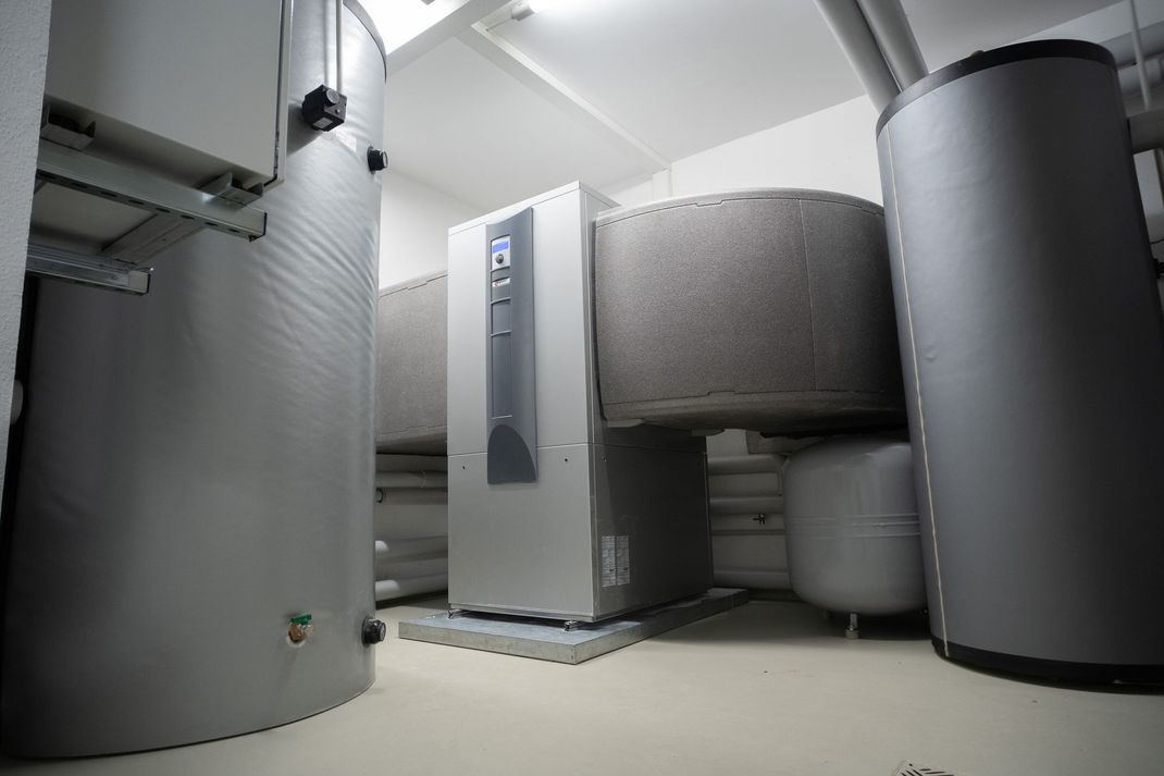 Mechanical equipment room with large silver and black HVAC units and ducts in a clean industrial space