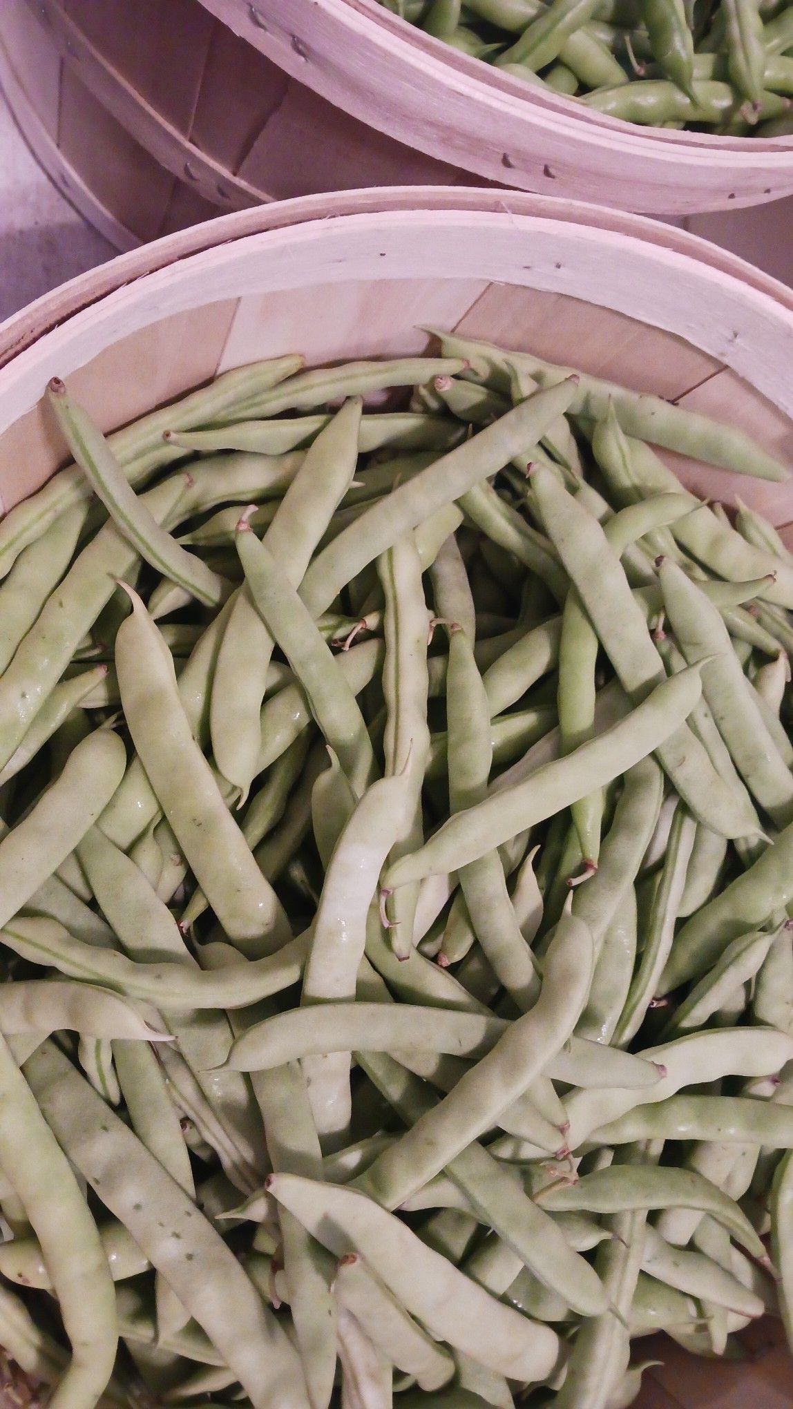 Green beans in a wooden basket.
