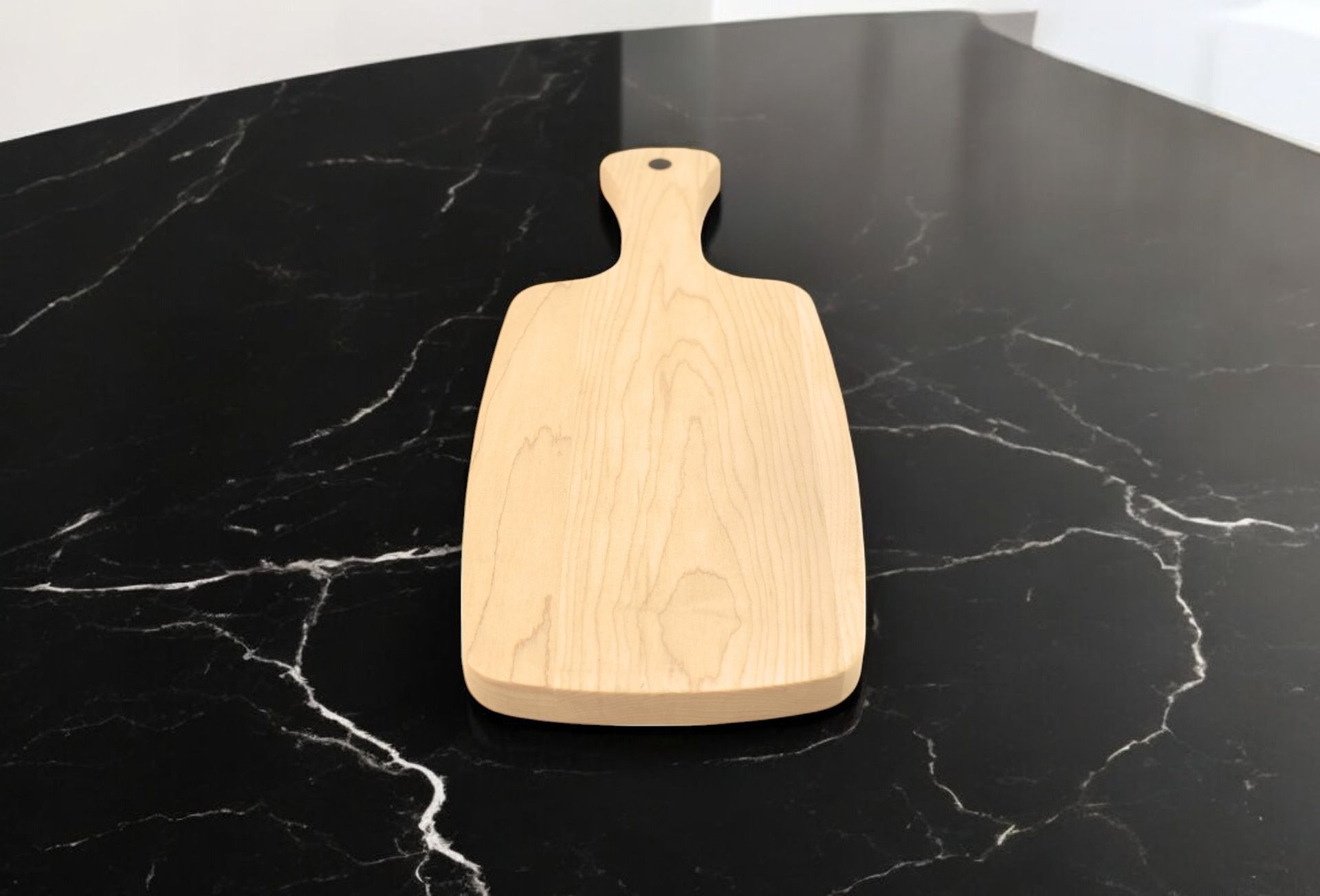 A wooden cutting board sits on a black marble counter top