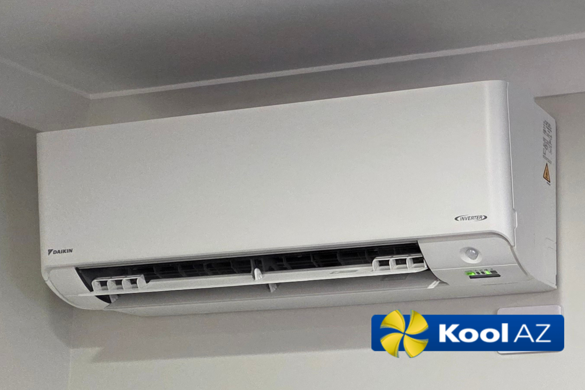 A white air conditioner is sitting on a white surface.