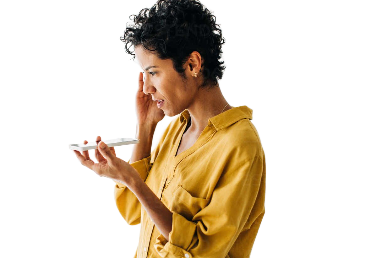 A person in a yellow shirt holds a smartphone horizontally near their face, appearing to listen to or speak into it.