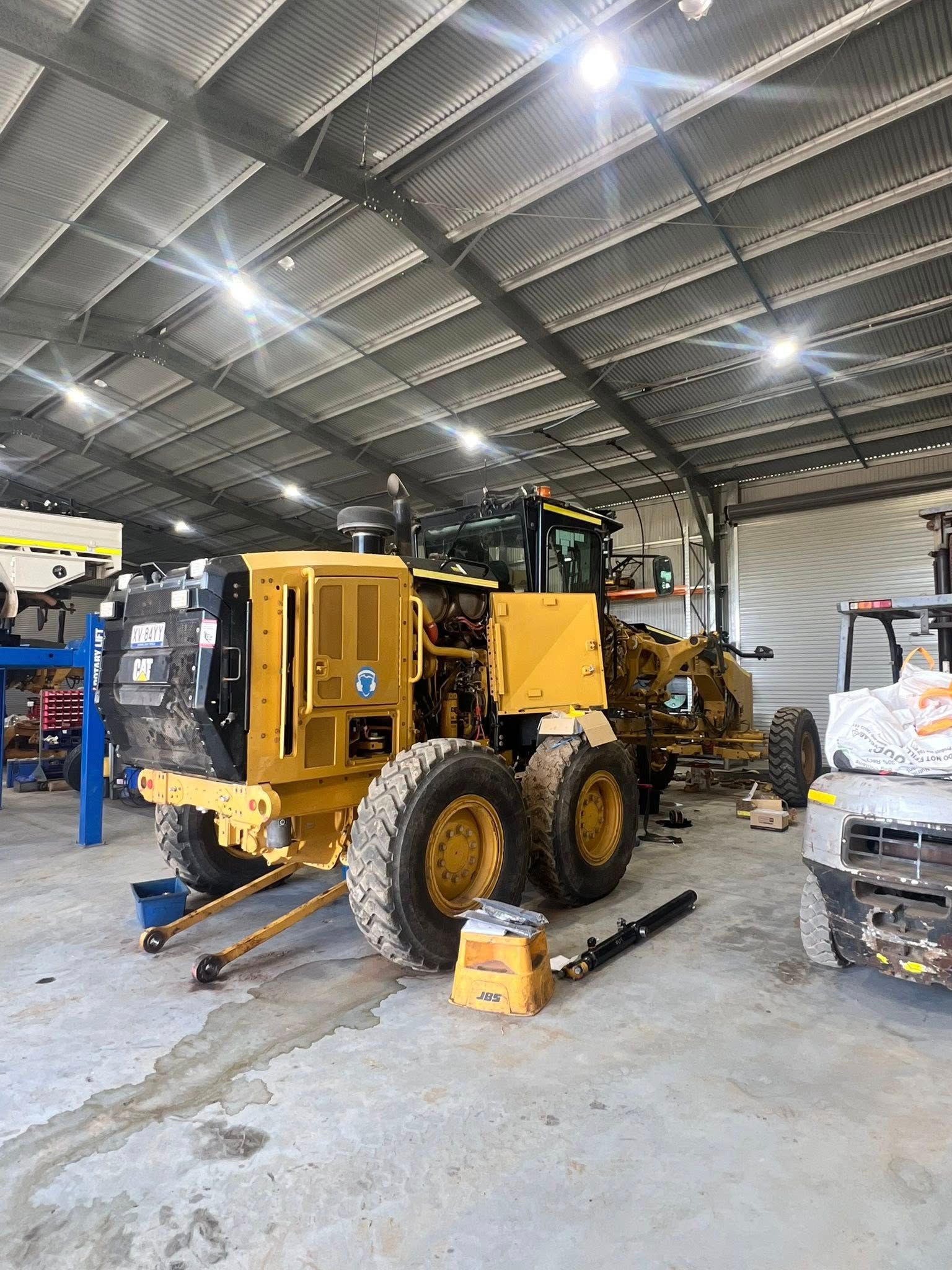 Yellow Grader Being Repaired Inside a Metal-roofed Workshop — HOLESHOT Diesel In Emerald, QLD