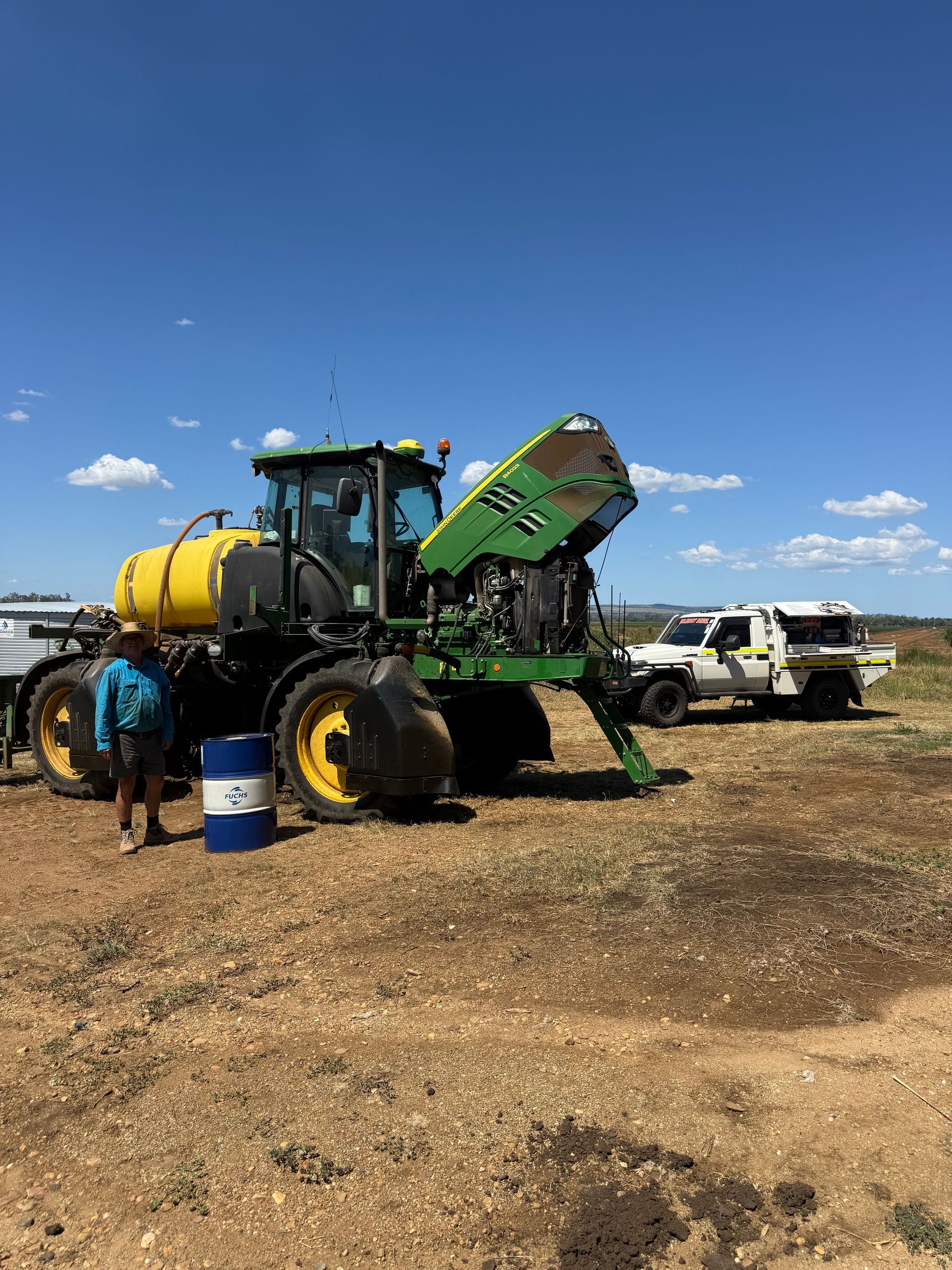 A Person Stands Next to a Large Green and Yellow Tractor — HOLESHOT Diesel In Gympie, QLD