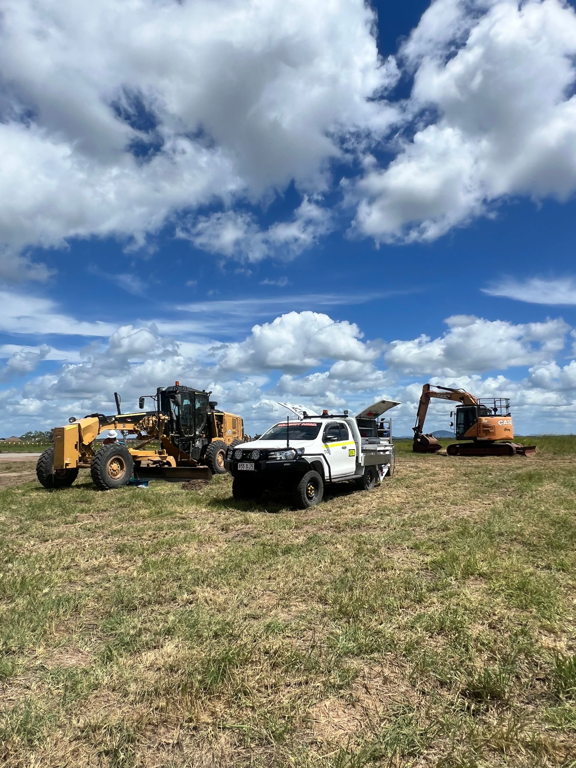 Construction Equipment on Field Under a Cloudy Blue Sky — HOLESHOT Diesel In Kingaroy, QLD