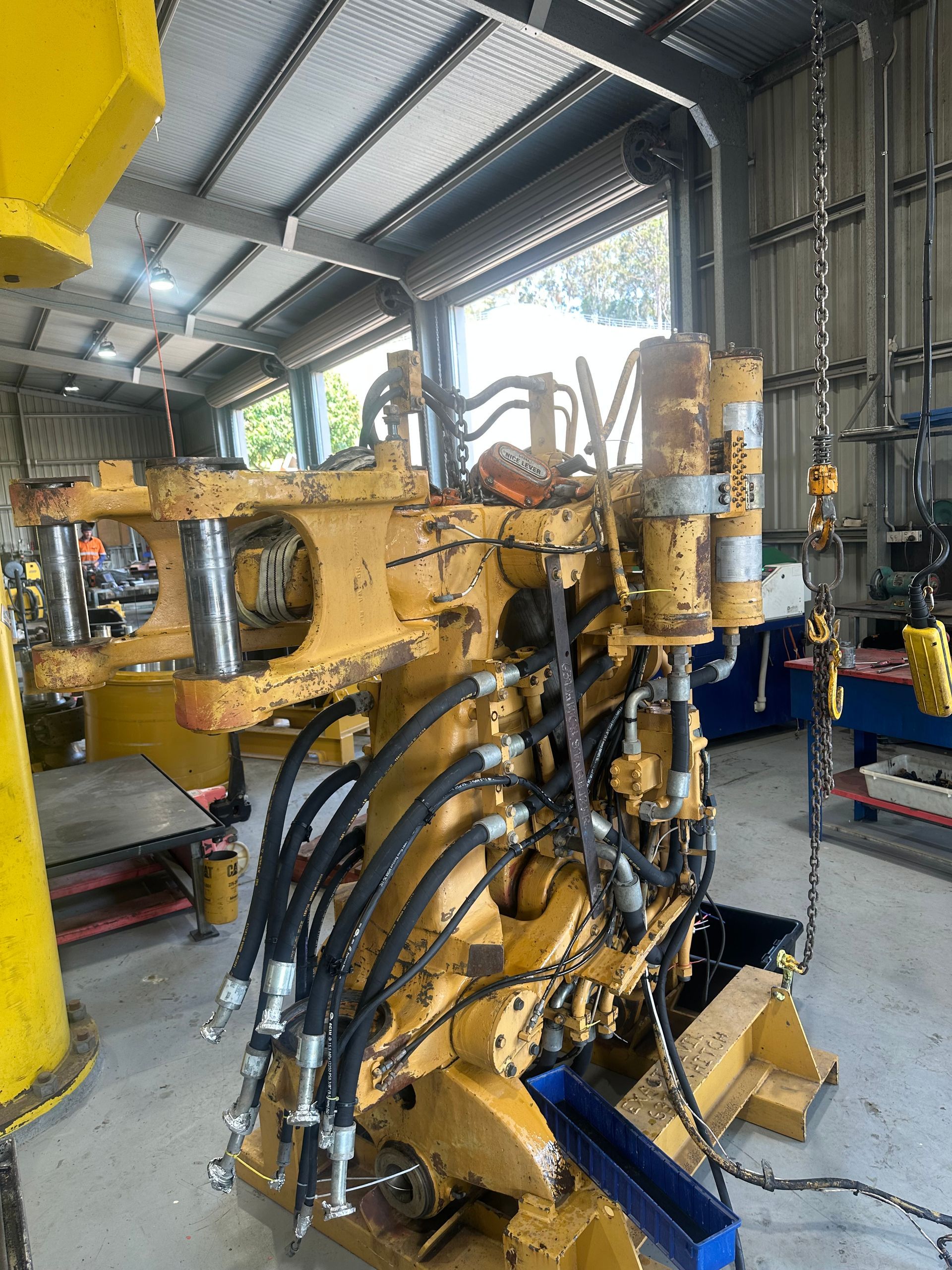 Yellow Industrial Machine With Hydraulic Hoses Inside a Workshop — HOLESHOT Diesel In Brisbane, QLD