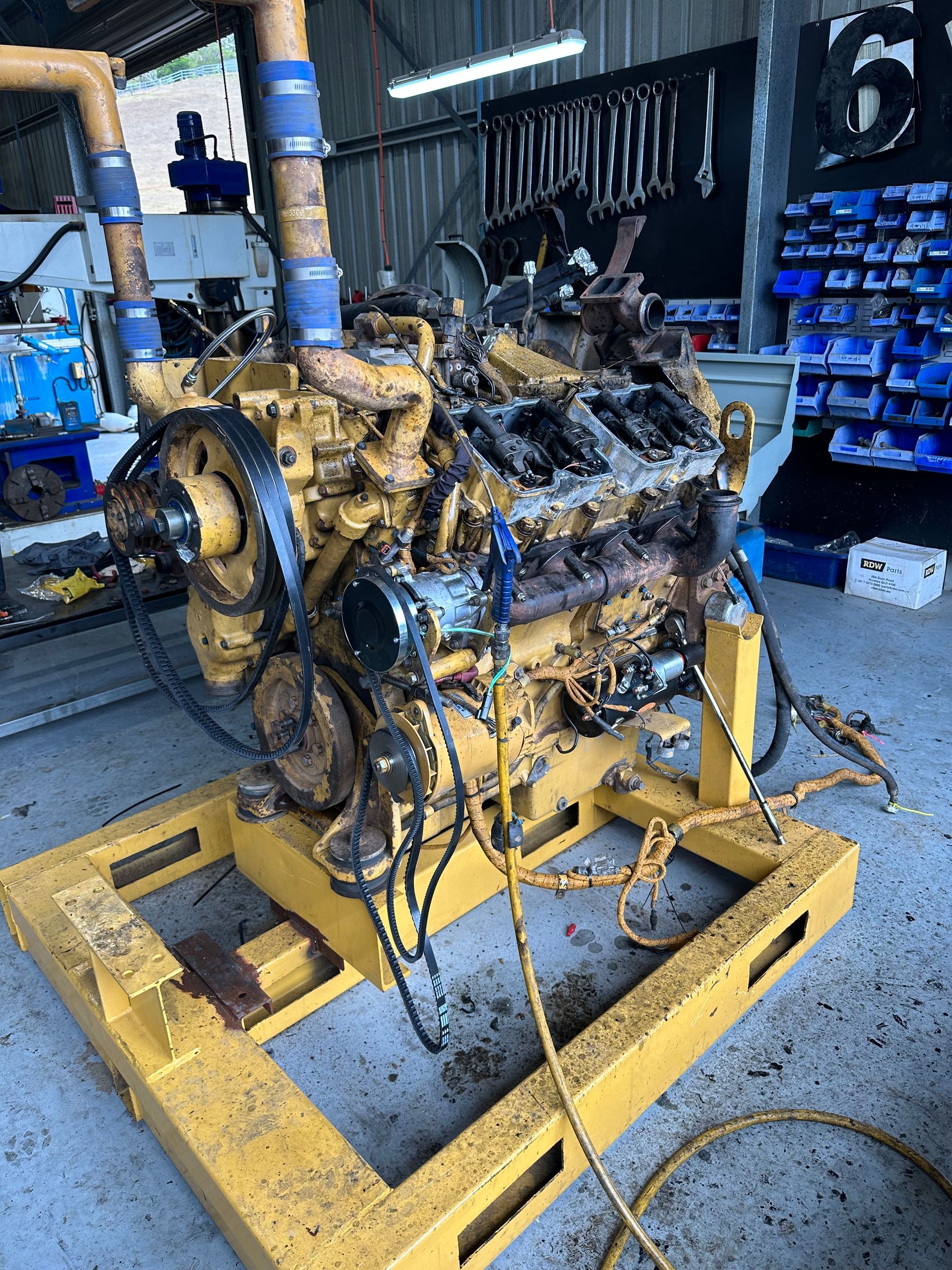 Yellow Caterpillar Engine on a Yellow Stand in a Garage — HOLESHOT Diesel In Gympie, QLD