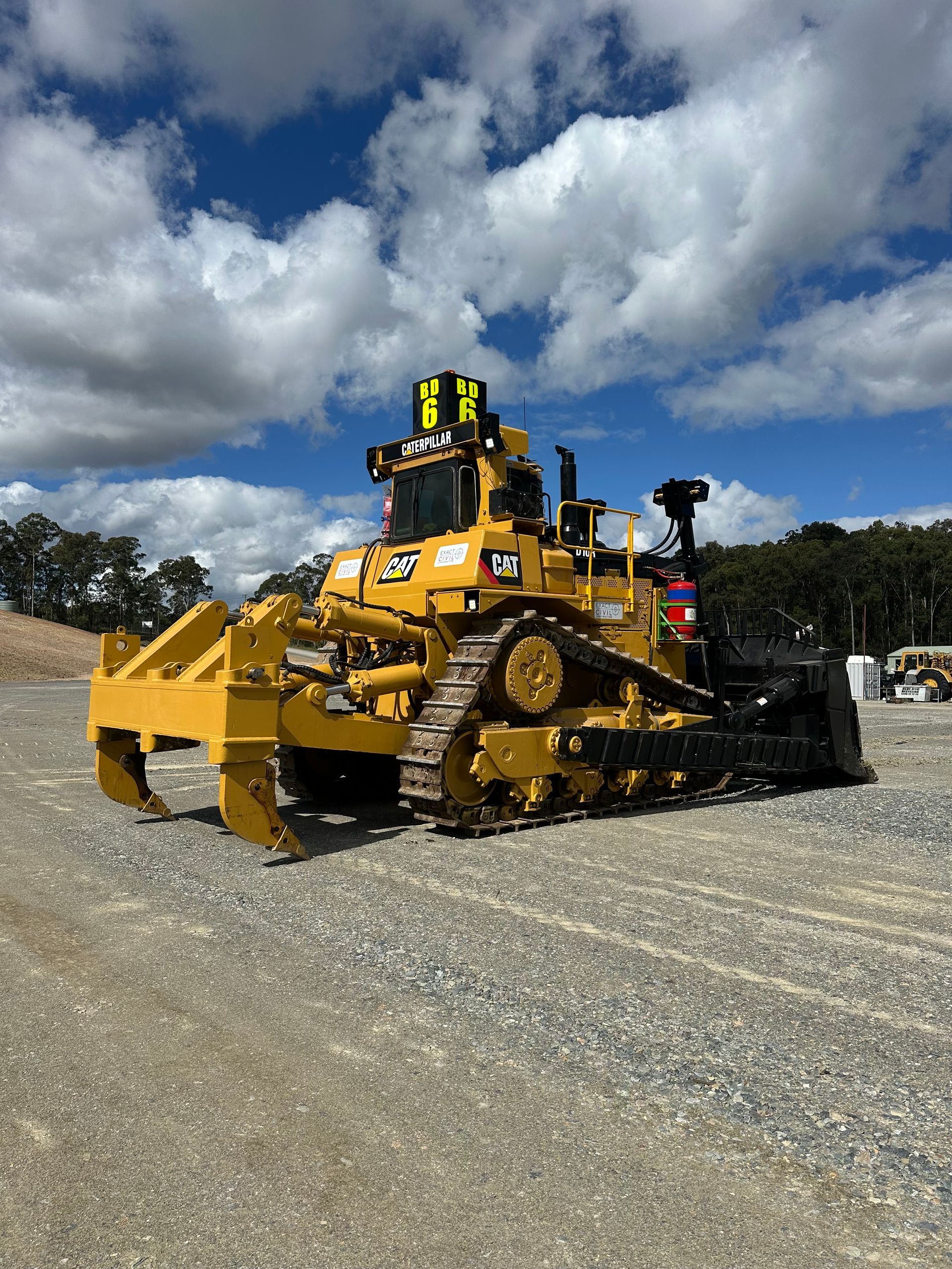 Yellow Caterpillar Bulldozer on Gravel Under a Cloudy Blue Sky — HOLESHOT Diesel In Gympie, QLD