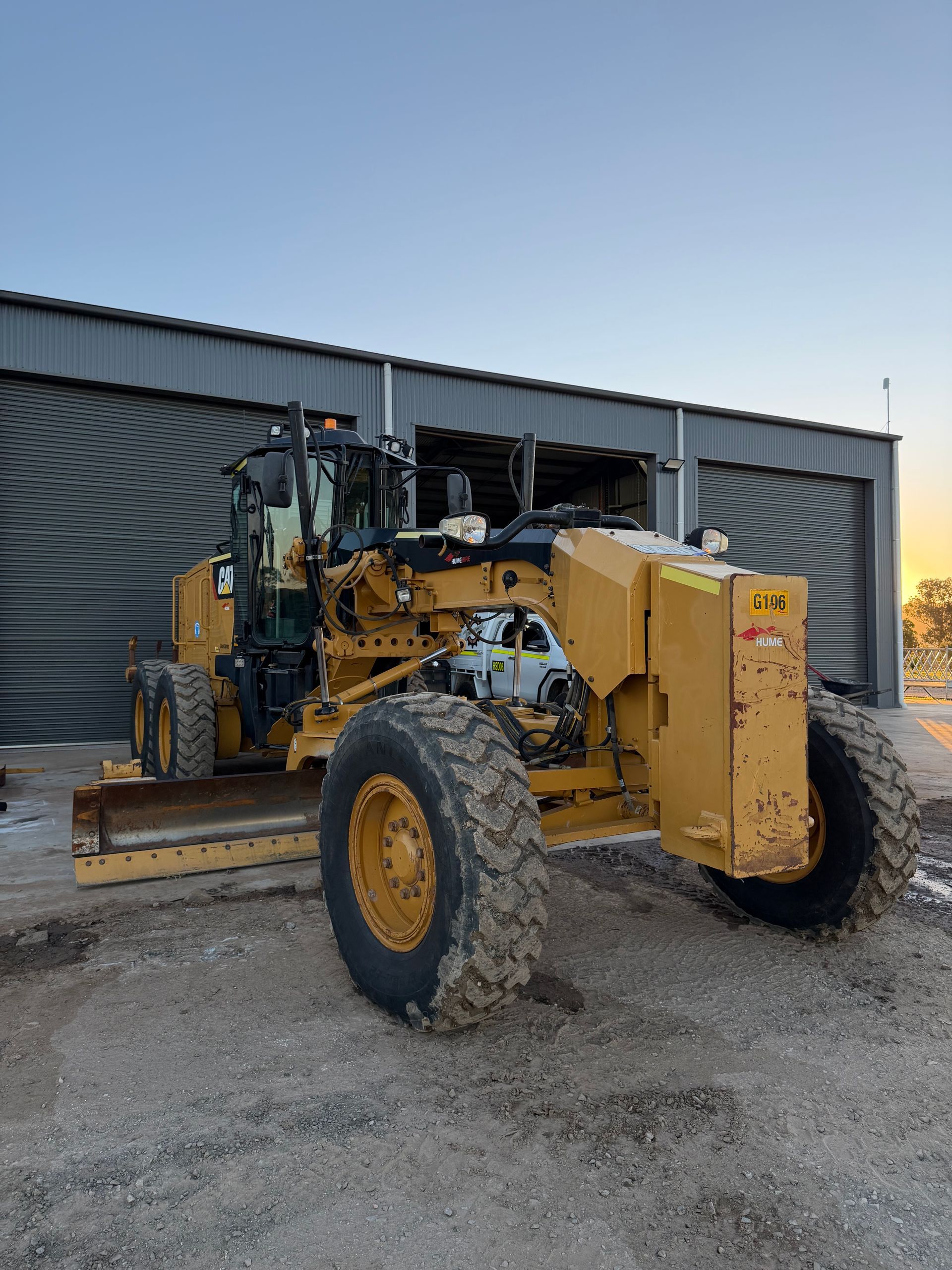 Yellow Grader Parked in Front of a Metal Building — HOLESHOT Diesel In Gympie, QLD