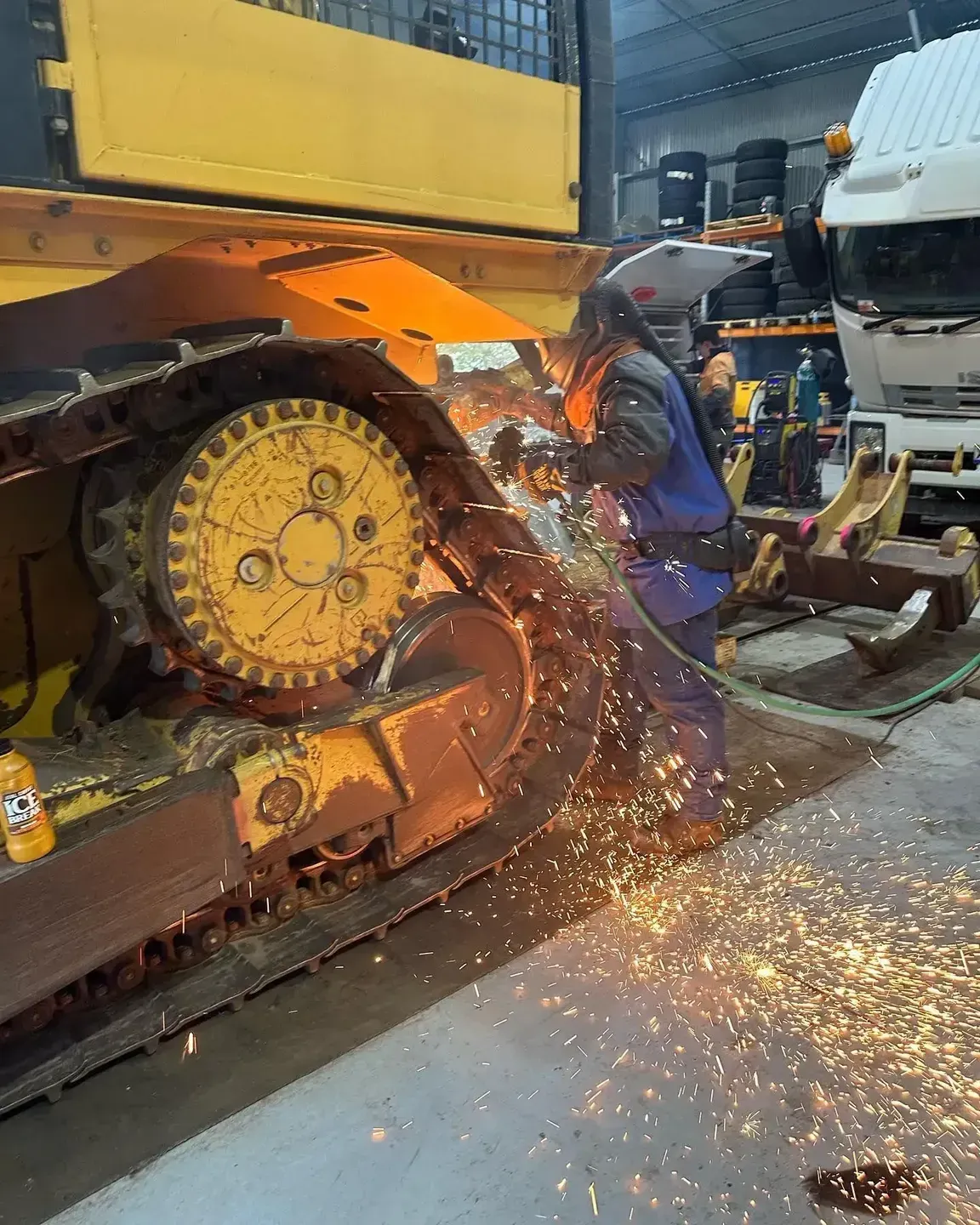 A Person Welds on Heavy Machinery, Creating Sparks, in a Workshop — HOLESHOT Diesel In Maryborough, QLD