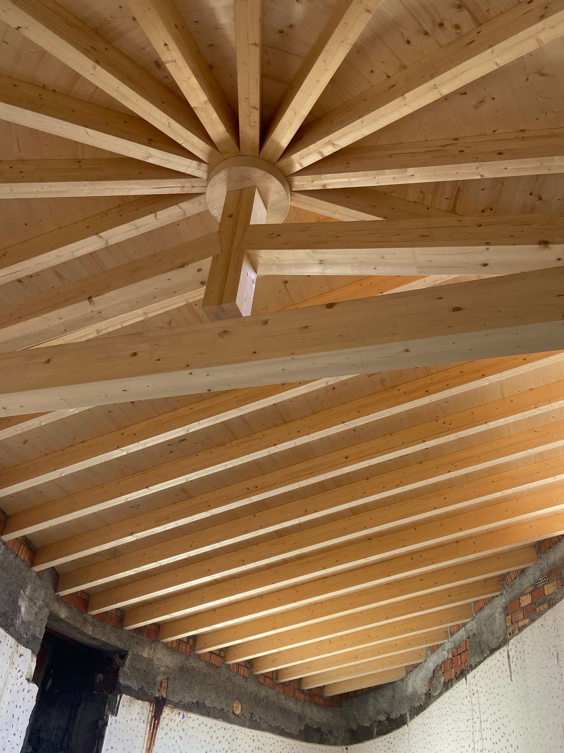 Struttura del soffitto in legno con travi radiali che partono da un fulcro centrale.