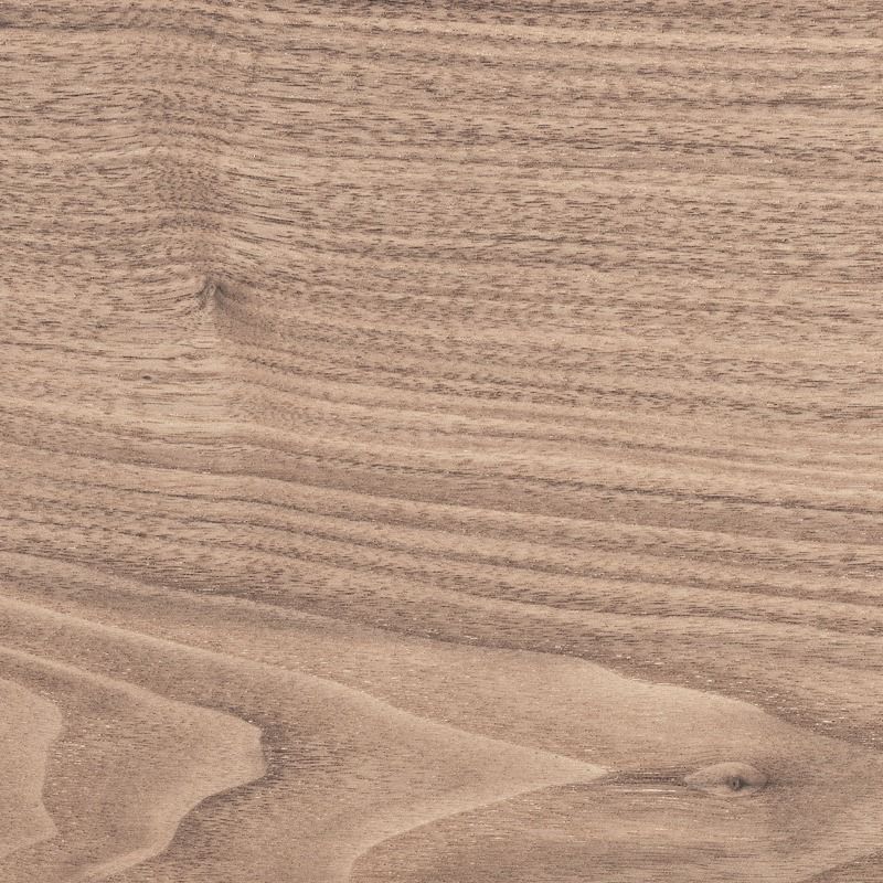 Primo piano di una superficie in legno marrone chiaro, con linee curve e strutturate.