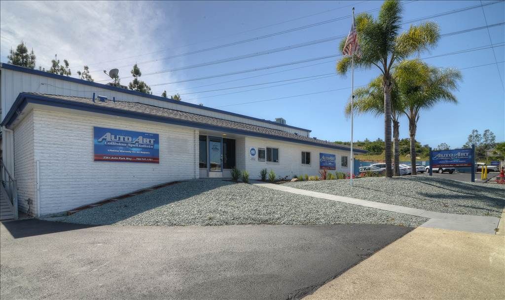 A white building with a blue sign that says ' aluminum ' on it