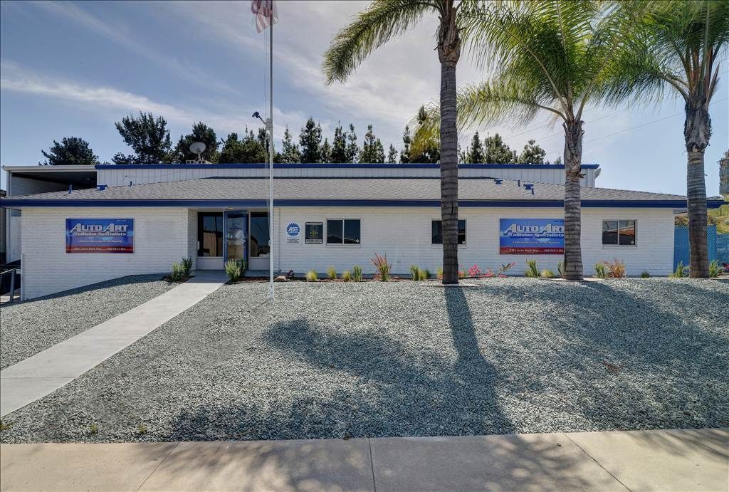 A white building with a blue sign that says ' suzuki ' on it