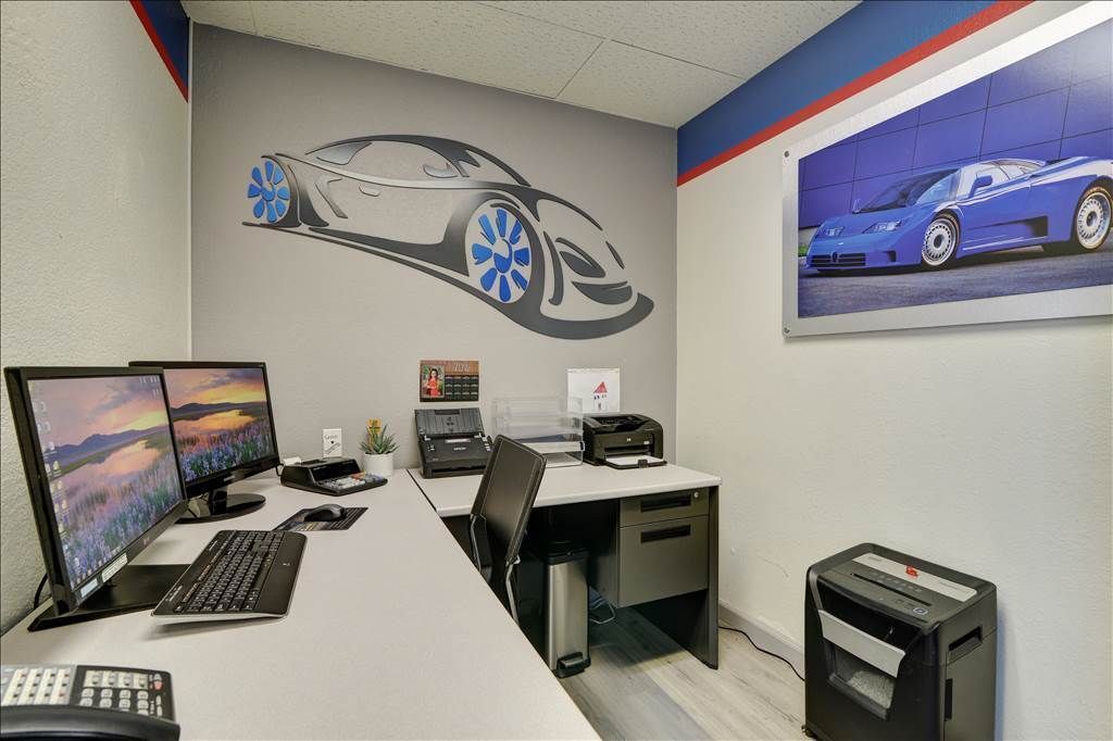 An office with a picture of a car on the wall