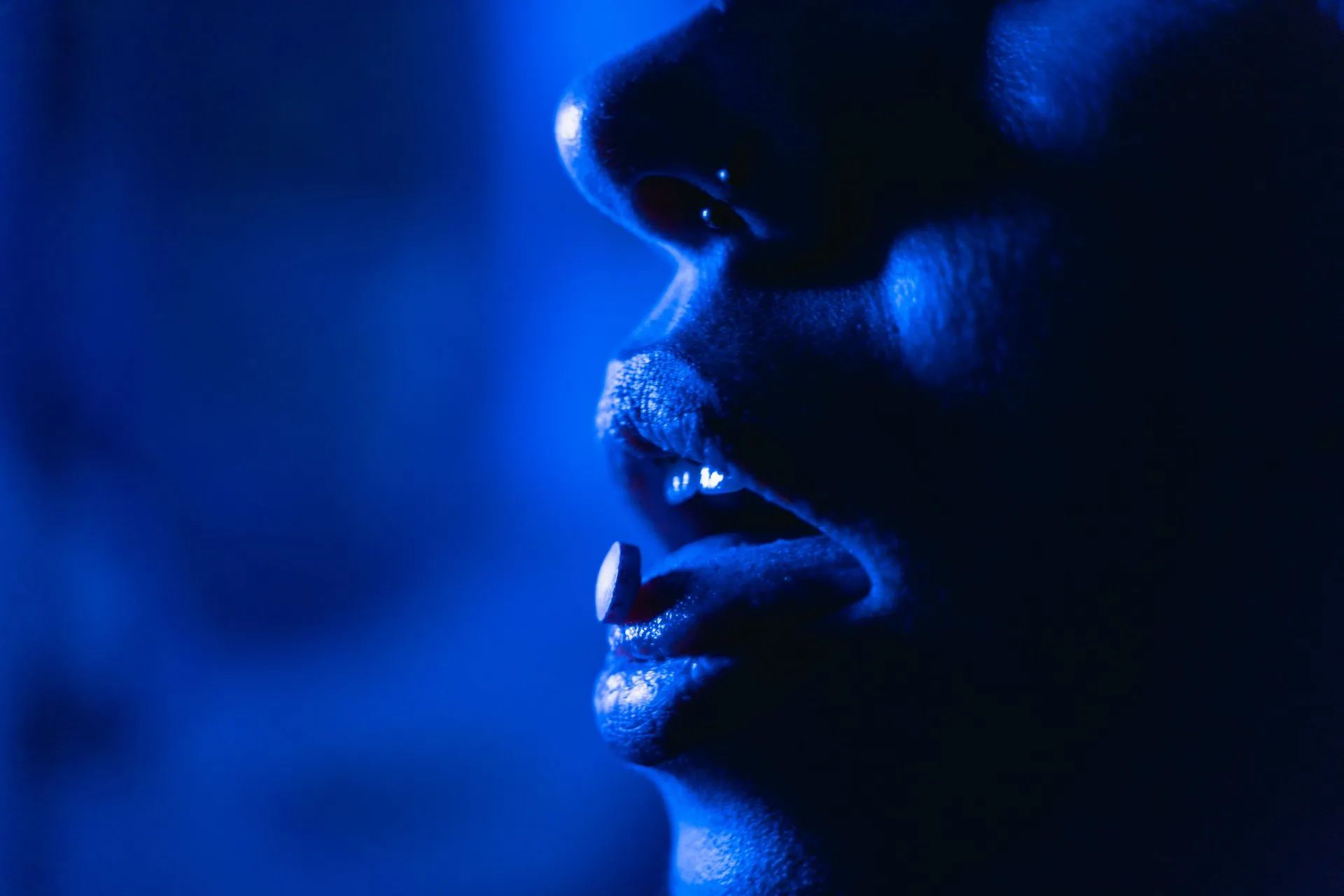 A close up of a woman 's face in a blue light.