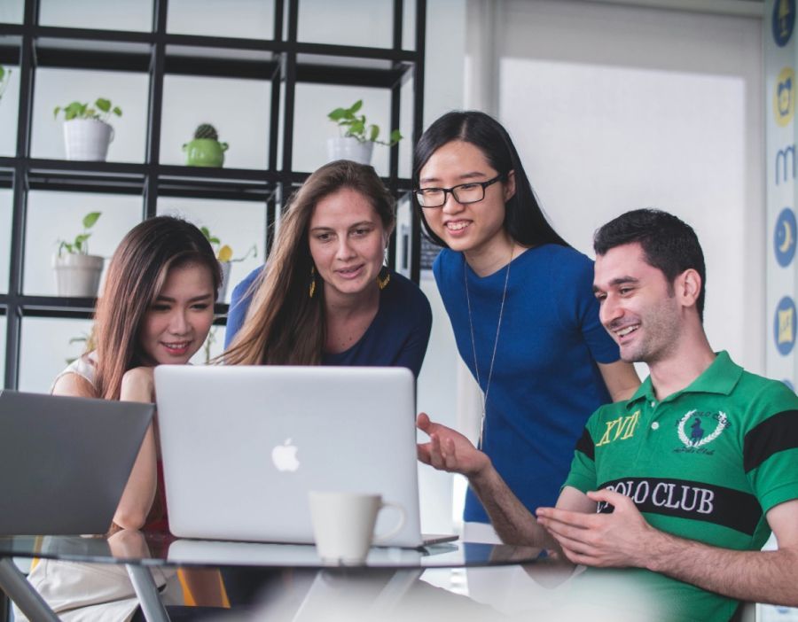 A group of people are looking at a laptop computer.