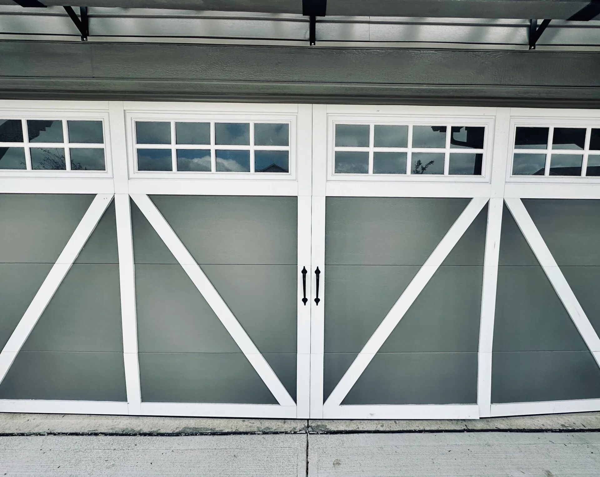 Gray garage door with white trim and small window panes above.