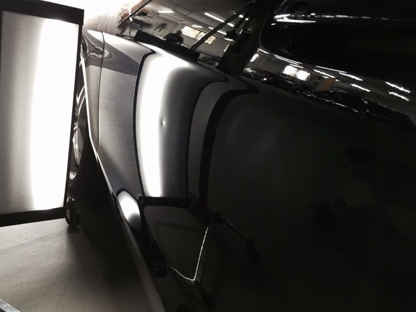 A Black Car Is Sitting In A Dark Room With The Door Open — Rapid Auto Dent In West Gosford, NSW