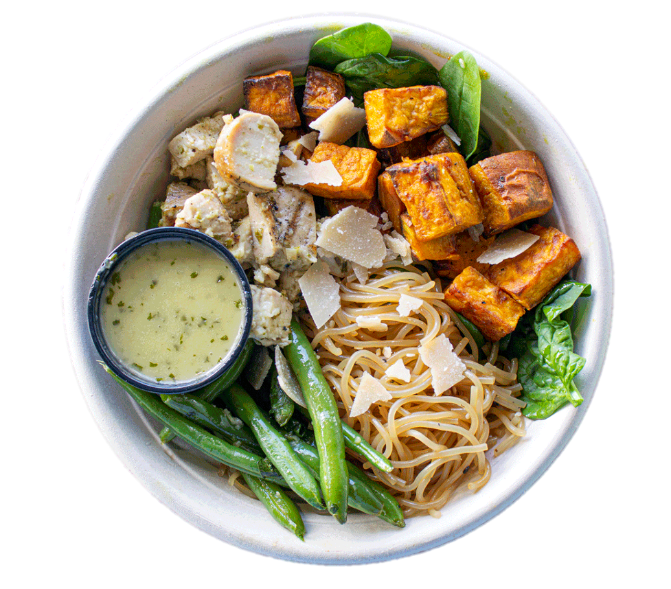 A bowl of food with noodles , green beans , tofu and a dipping sauce.