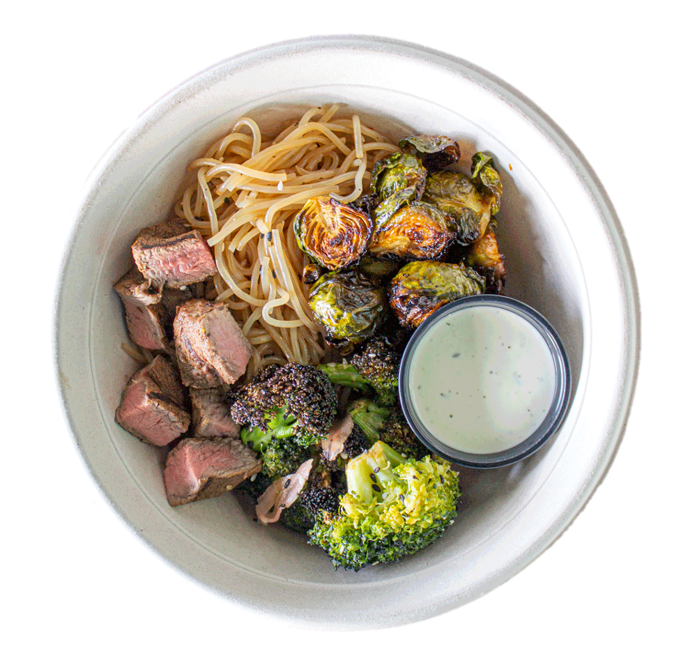 A bowl of noodles , broccoli , steak and brussels sprouts with a dipping sauce.