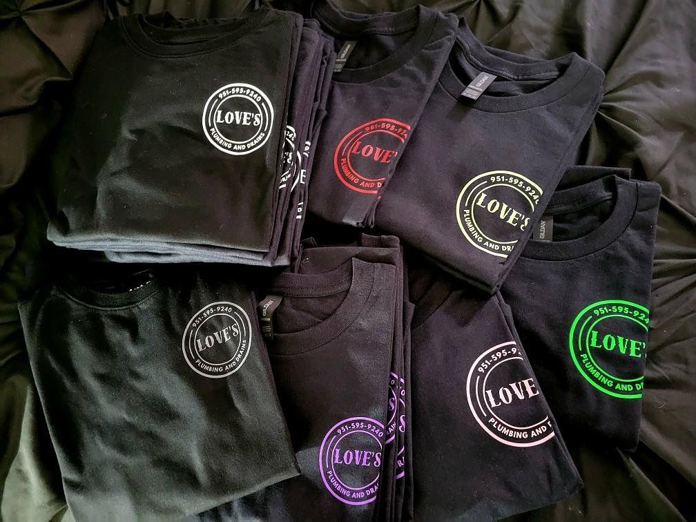 Seven black t-shirts with white and colored