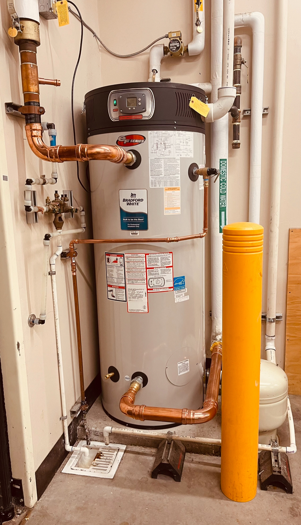 Two water pressure gauges and pipes on a white wall, with electrical boxes and filters.