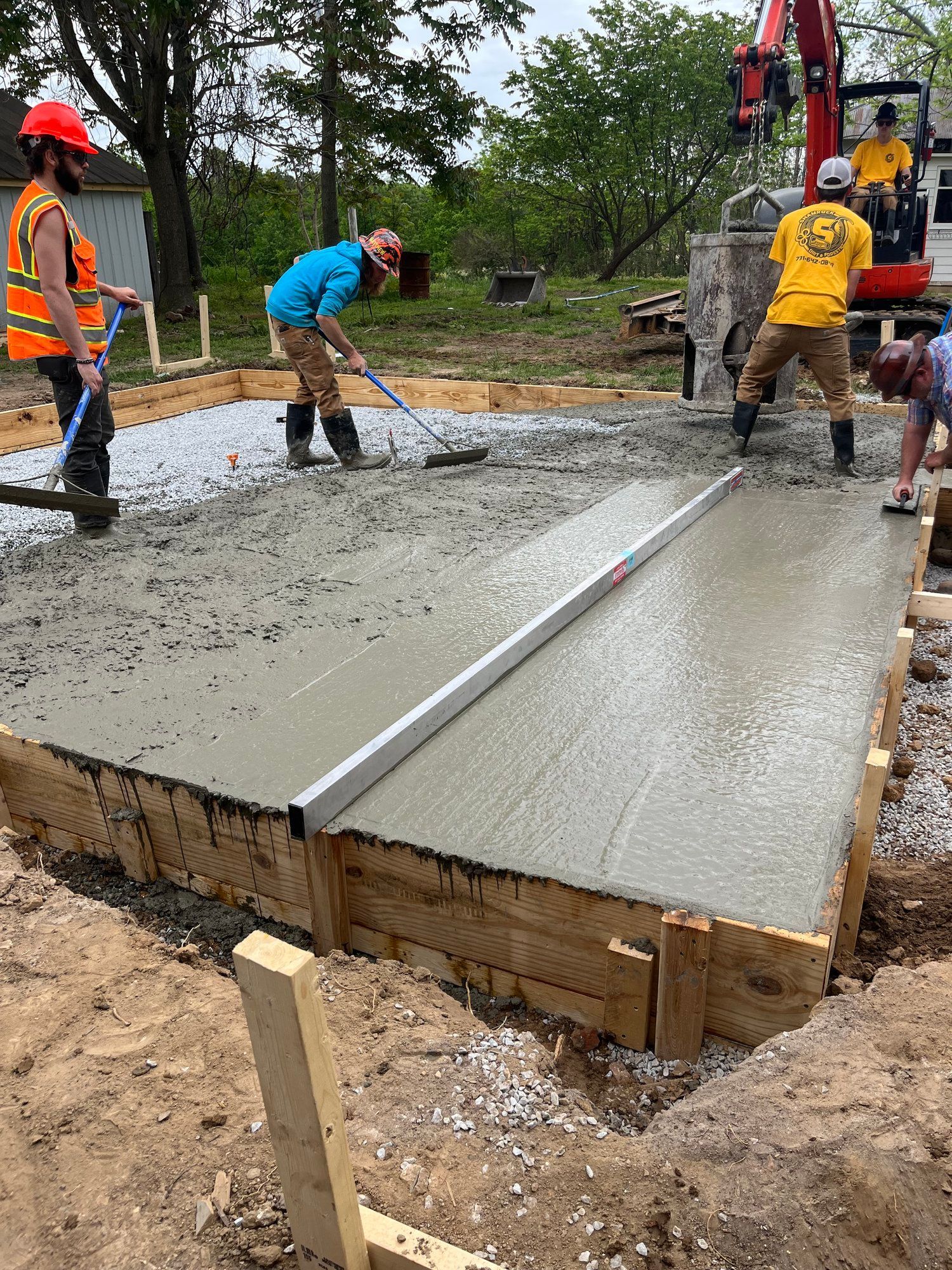 A group of construction workers are working on a concrete floor.
