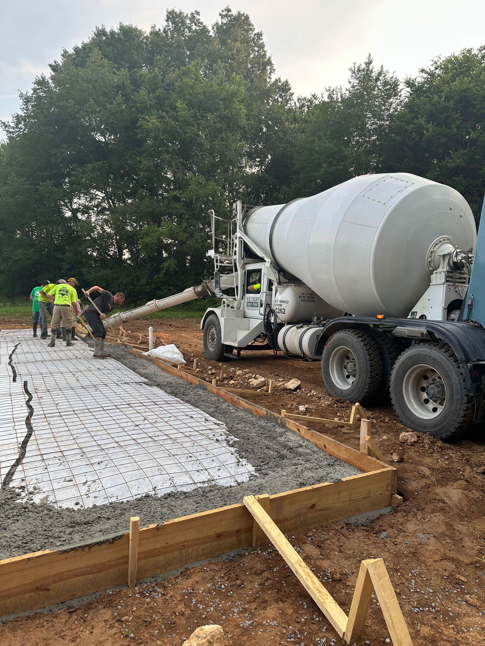 A concrete mixer truck is pouring concrete on a construction site.
