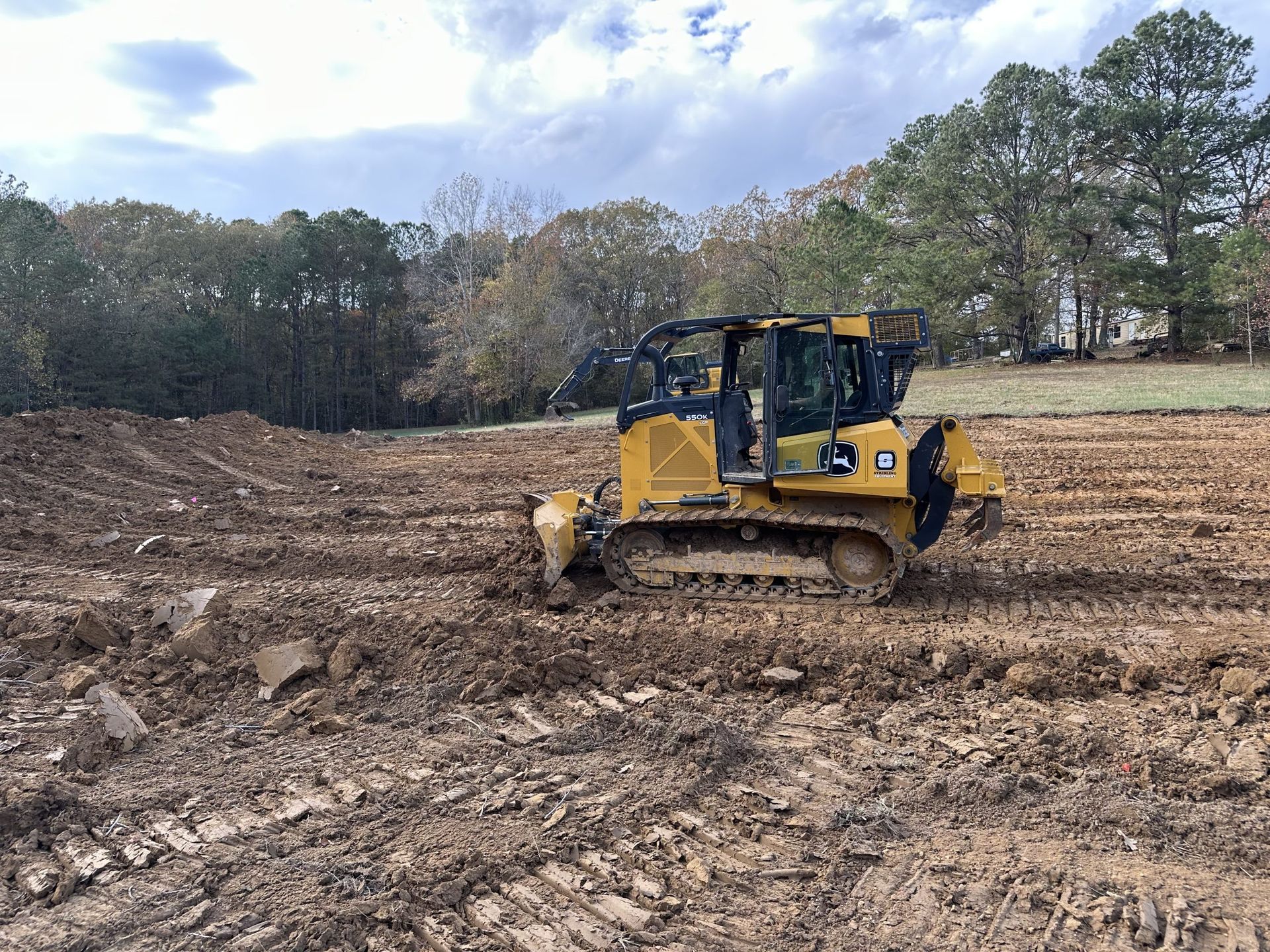 A bulldozer is driving through a muddy field.