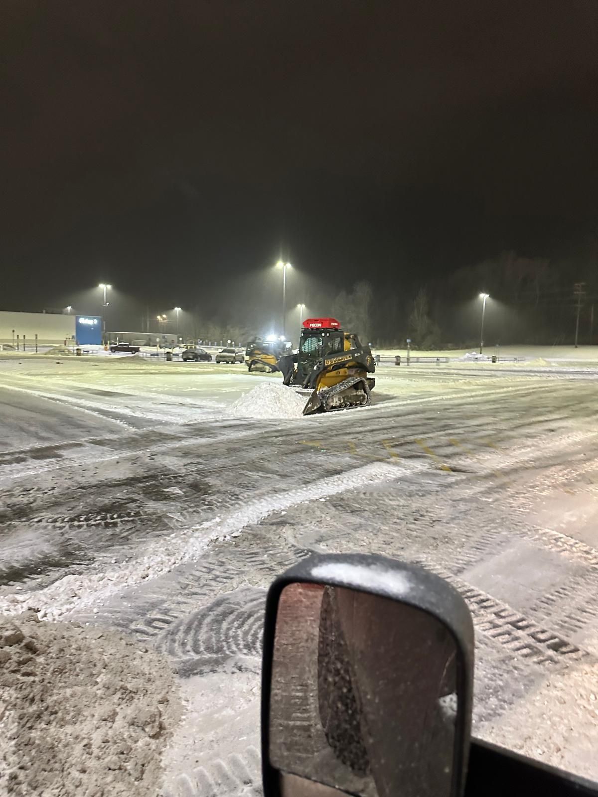 A Walmart parking lot during snow removal and salting services.