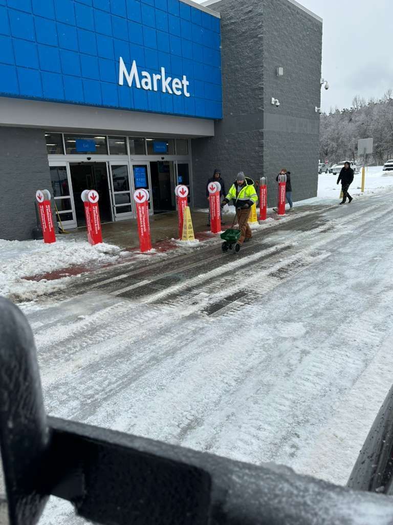 A Shamrock Dirt and Forestry worker clearing a Walmart parking lot of snow.