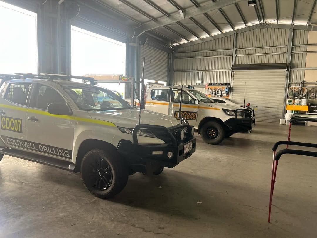 Two White Trucks Are Parked In A Garage — Windscreen Ambulance In Kawana, QLD