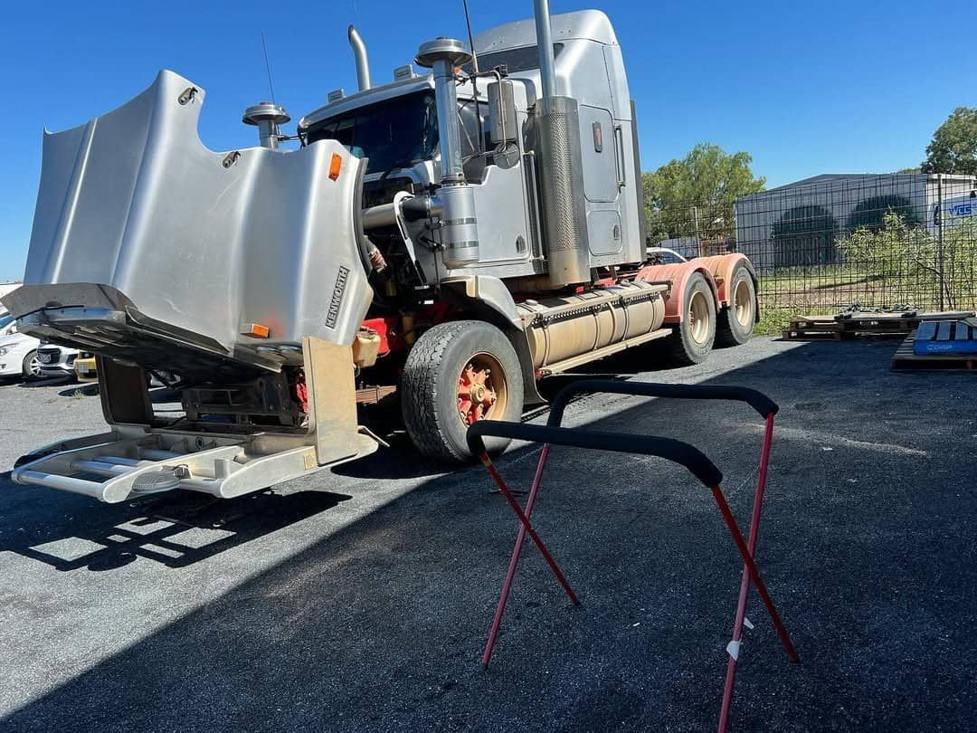 A Semi Truck With Its Hood Up Is Parked In A Parking Lot — Windscreen Ambulance In Kawana, QLD