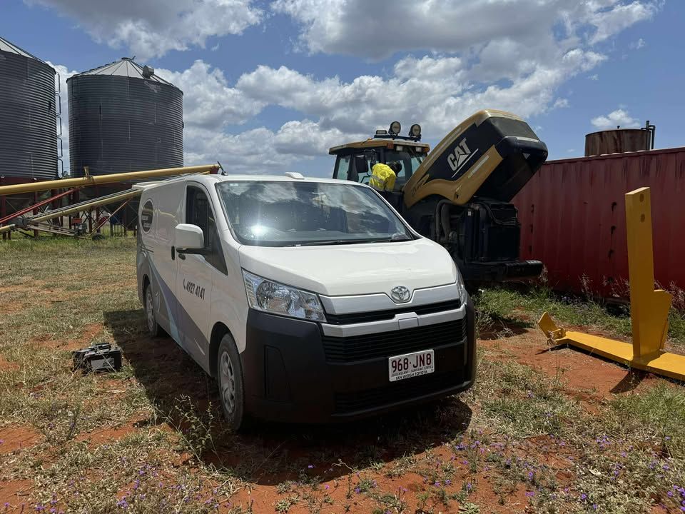 A White Van Is Parked In A Field Next To A Tractor — Windscreen Ambulance In Kawana, QLD