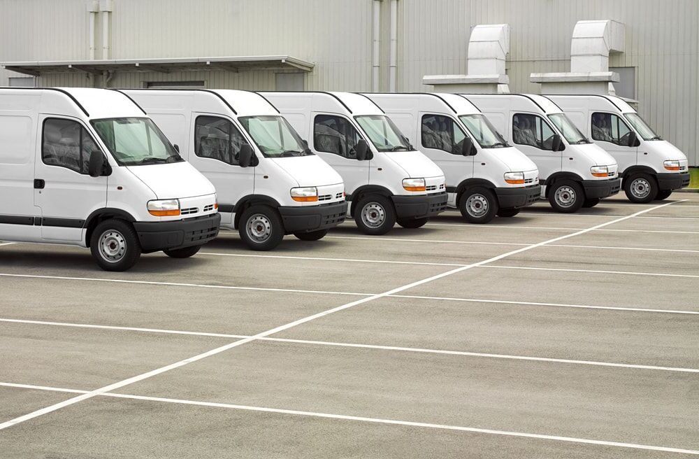 A row of white vans are parked in a parking lot — Windscreen Ambulance In Kawana, QLD