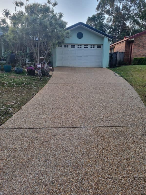 A driveway leading to a garage with a white garage door — Lighthouse pressure washing in Port Macquarie, NSW