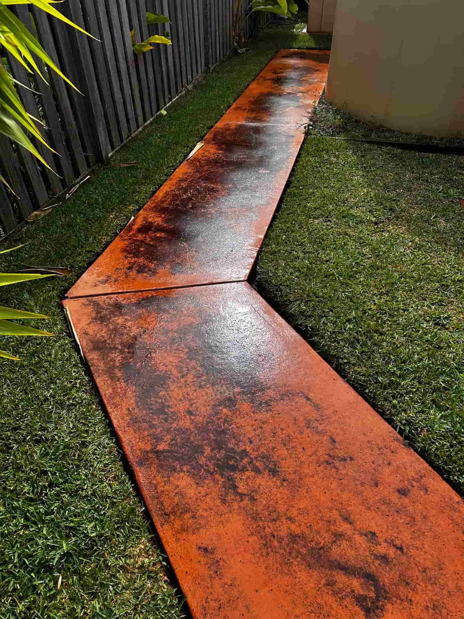 A dirty concrete walkway in a backyard next to a fence. — Lighthouse pressure washing in Port Macquarie, NSW
