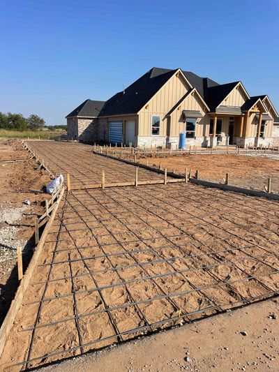 A house is being built in the middle of a dirt field.