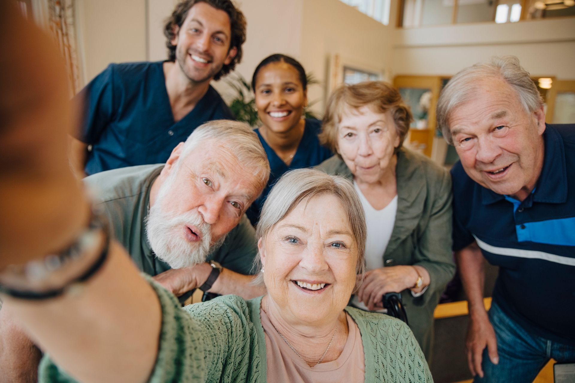 A group of elderly people are taking a selfie together in a nursing home.