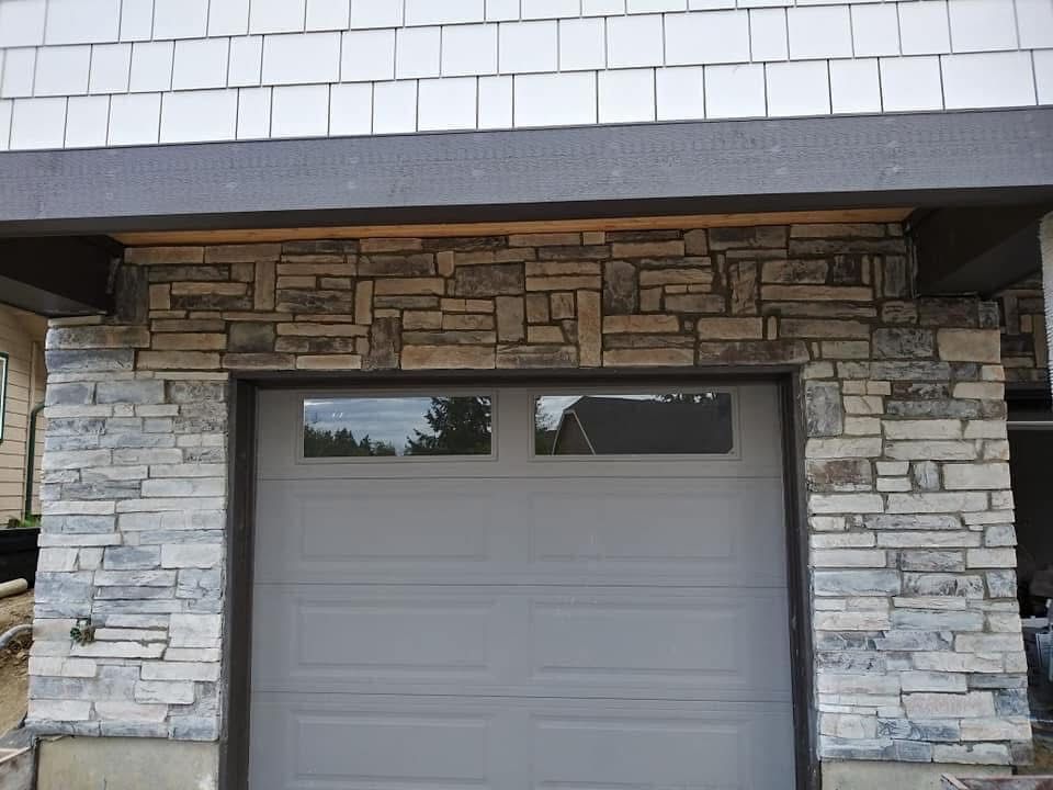 A garage door with a stone wall behind it