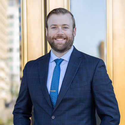 A man in a suit and tie is smiling for the camera.