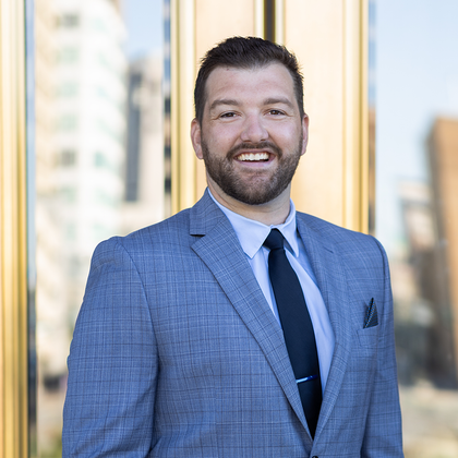 A man in a suit and tie is smiling for the camera.