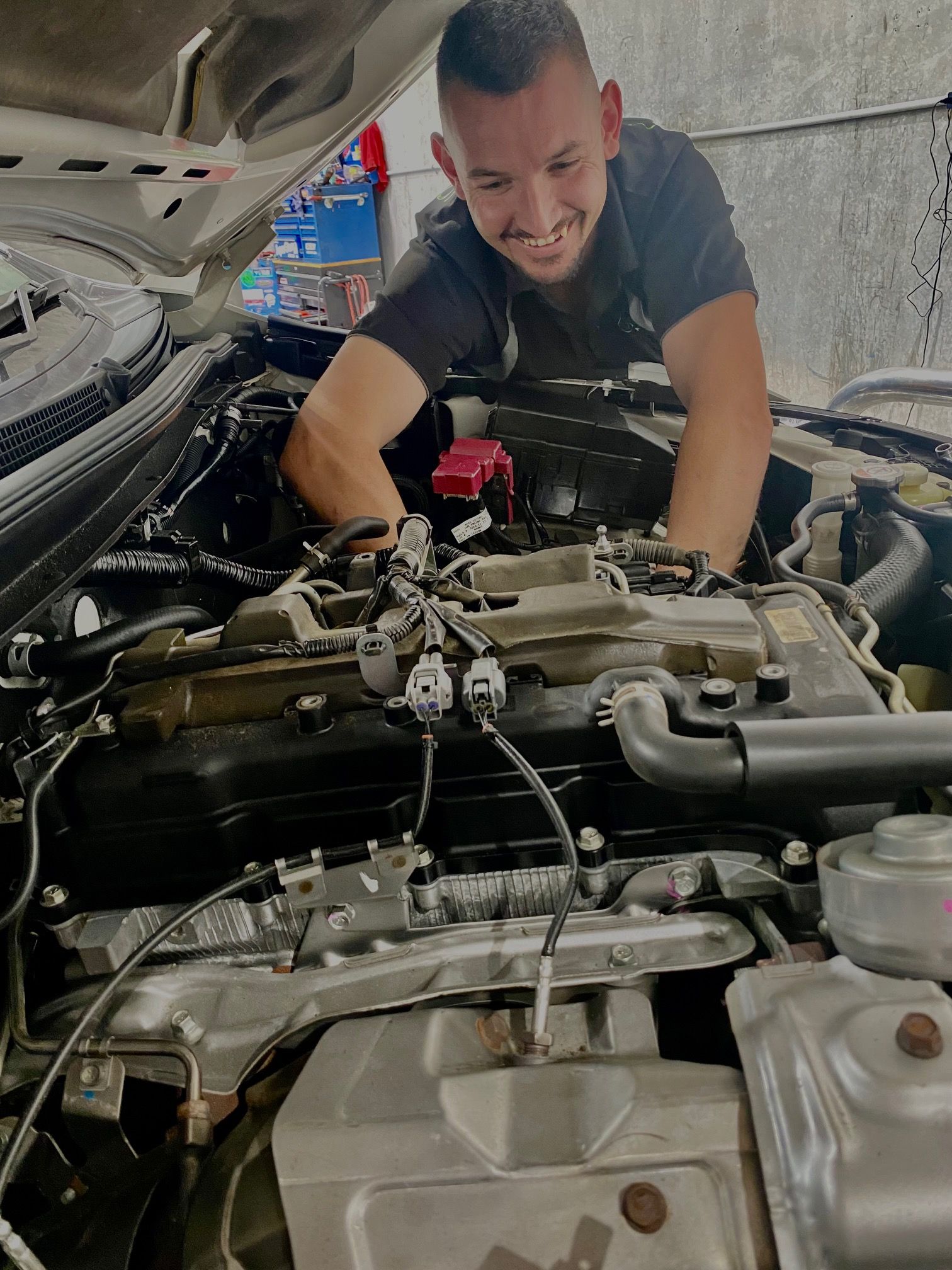 A man is working on the engine of a car.
