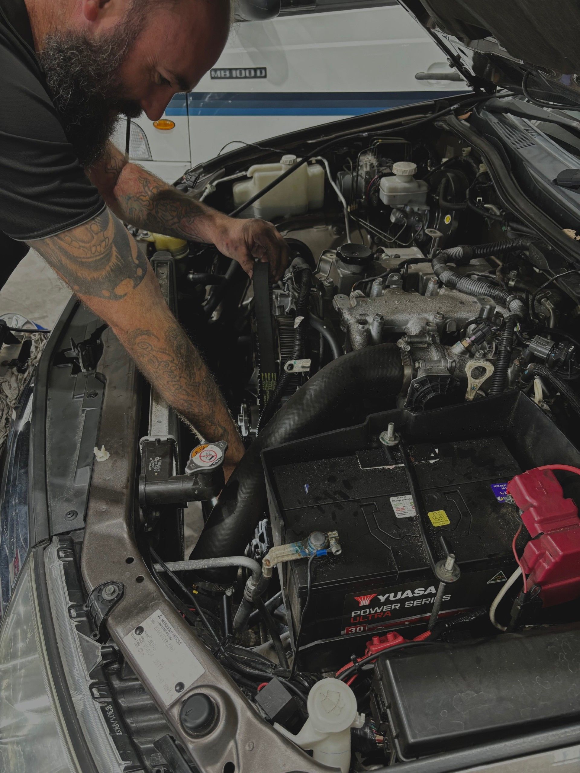 A man is working on the engine of a car.
