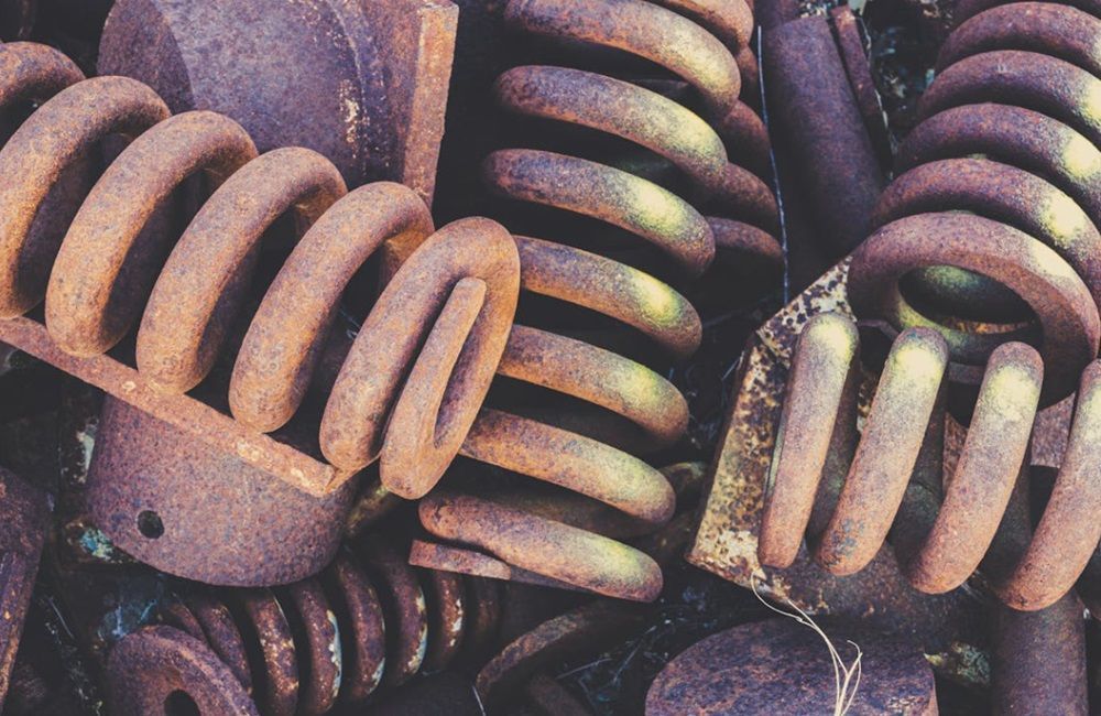 A bunch of rusty springs are sitting on top of each other.