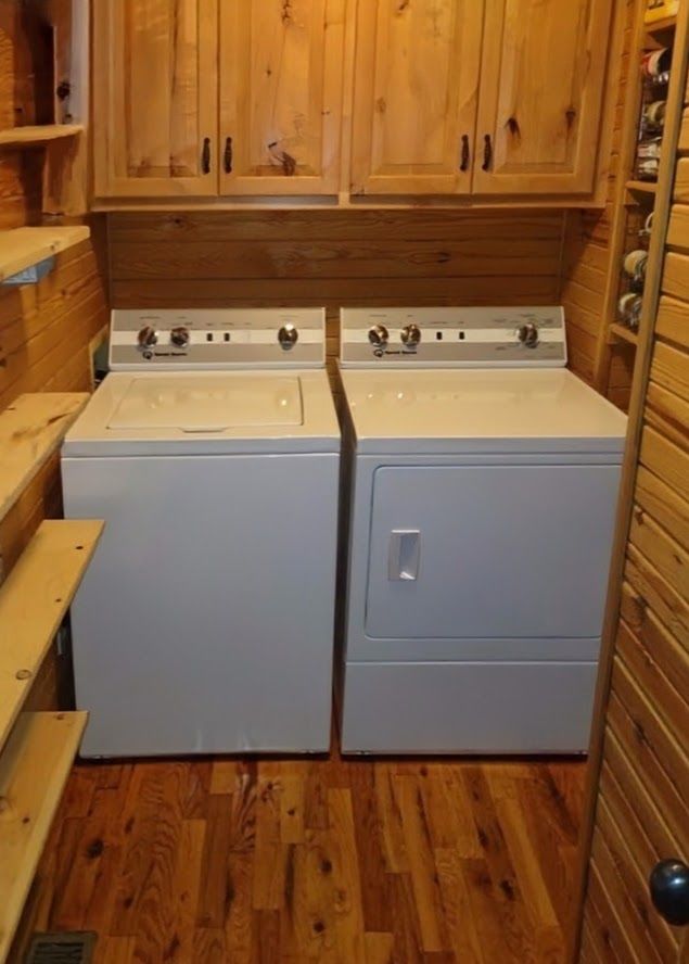 A laundry room with two white washers and dryers