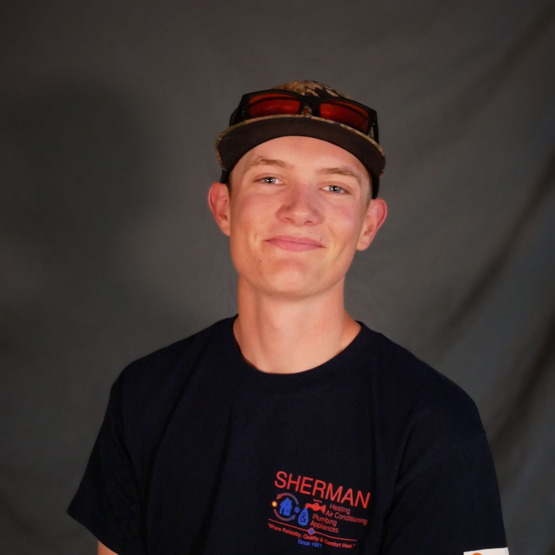 A young man wearing a sherman t-shirt and a hat