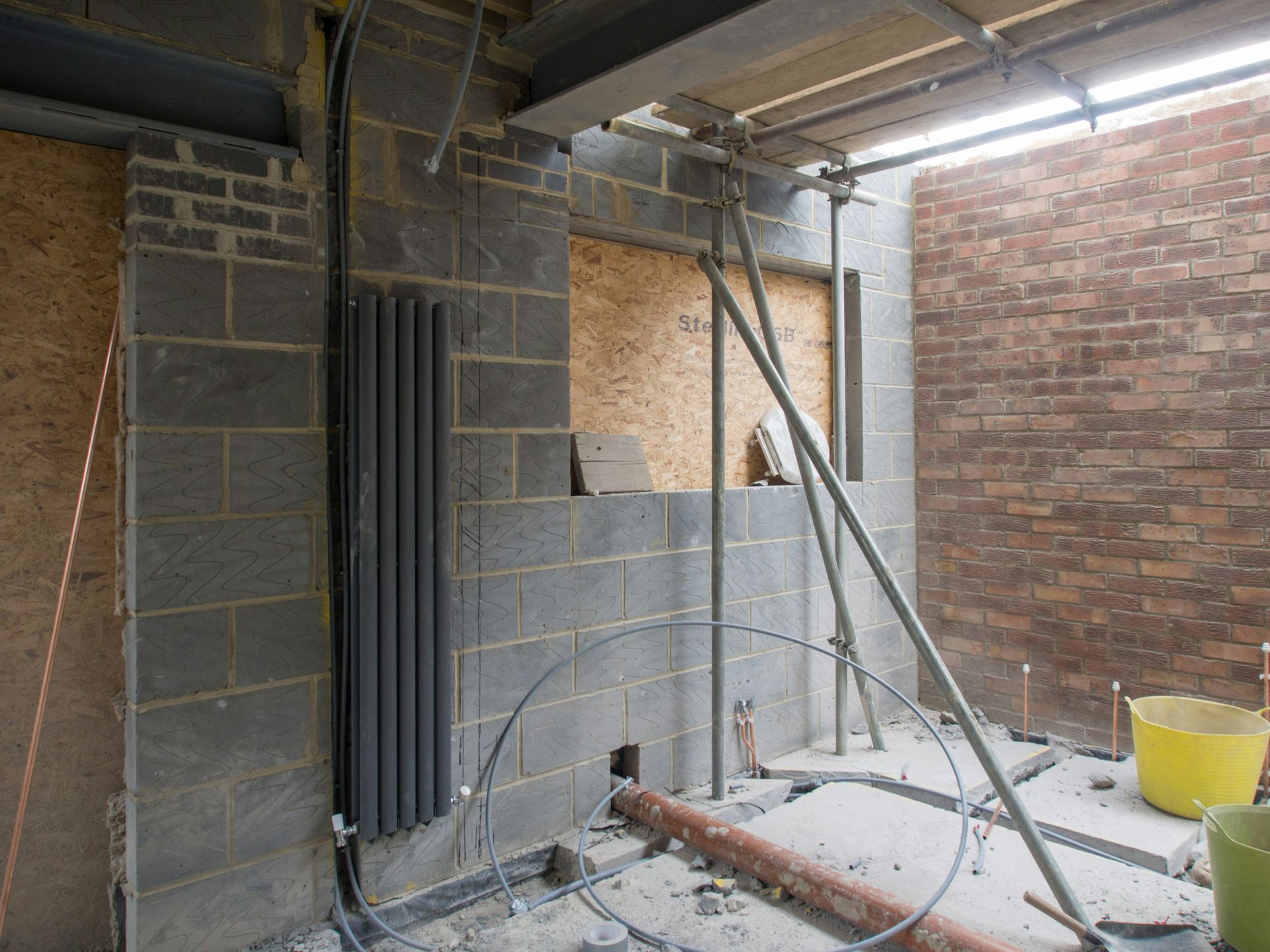 A brick wall is being built in a building under construction.