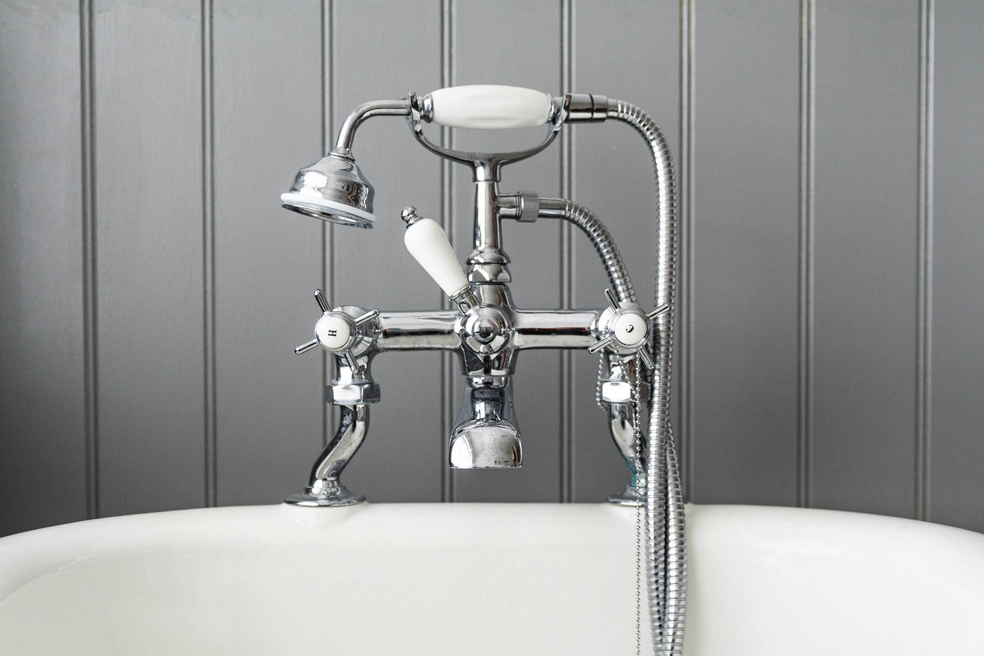 A bathtub with a chrome faucet and shower head.