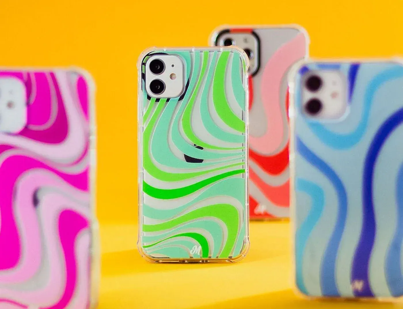Cuatro fundas coloridas para iPhone con patrones en forma de remolino.